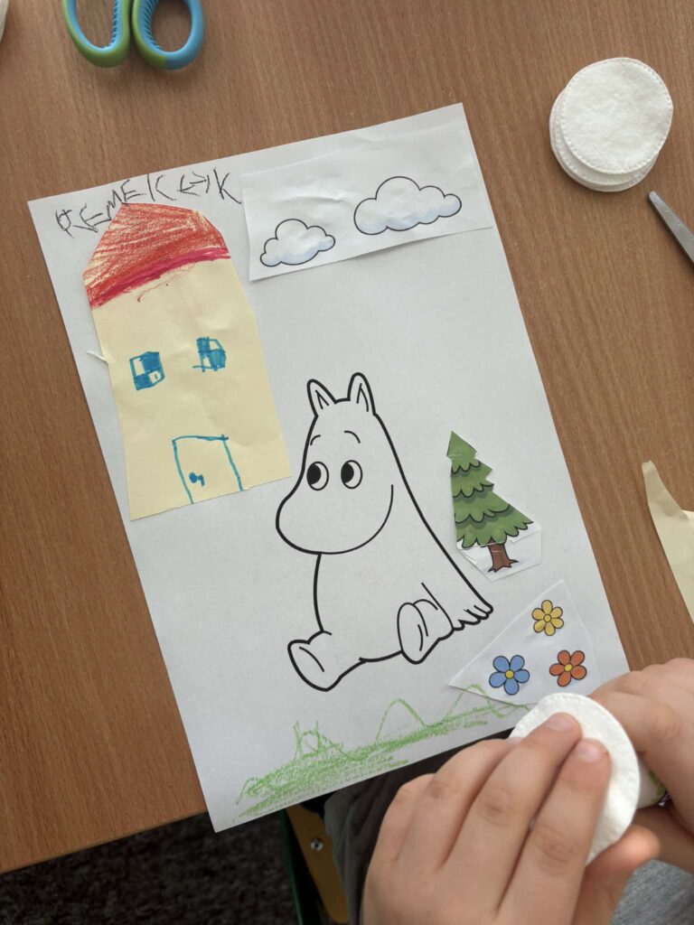 Na zdjęciu widać dziecko tworzące pracę plastyczną.